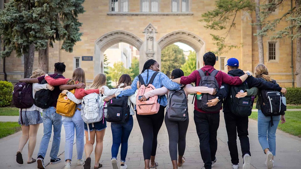 imgi 166 stthomas oiss international students walk in front of arches